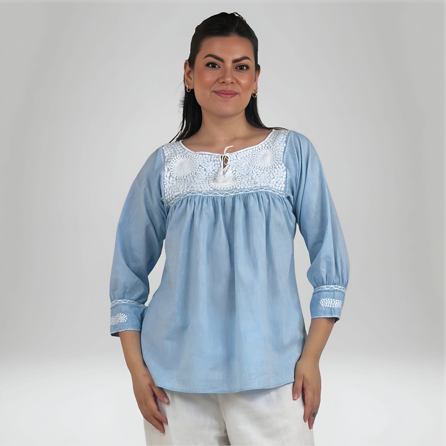 Blusa Aguacatenango Bolitas Algodón Celeste, bordado blanco, vista frontal en modelo.