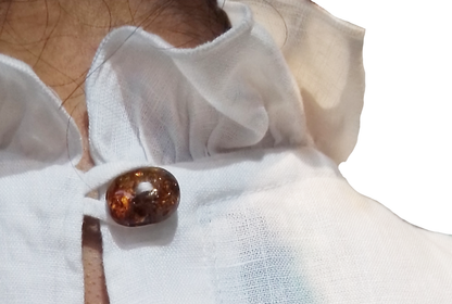 Blusa Lino con Vuelos y 1 Botón de Ámbar color blanco, detalle del botón de ambar.