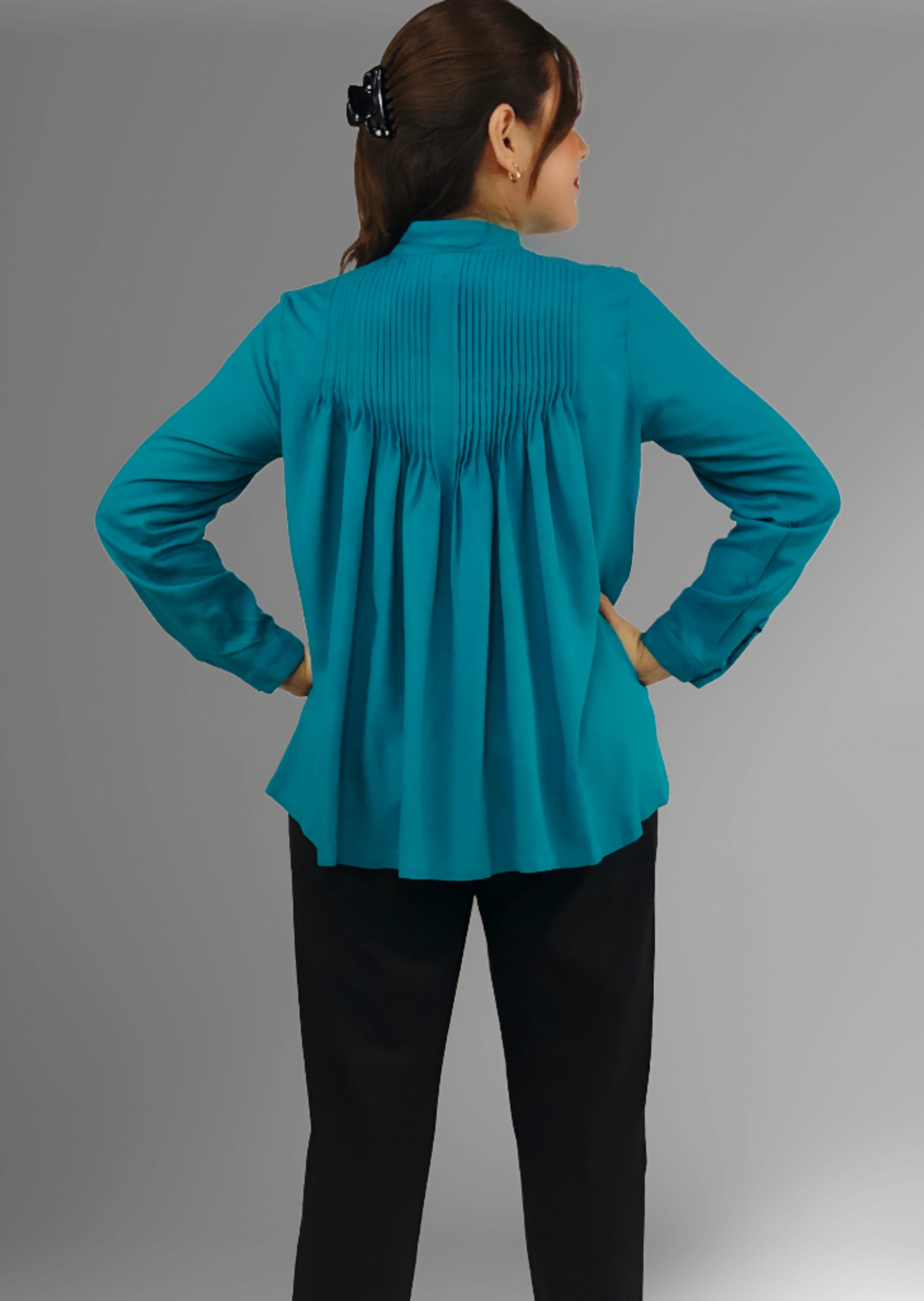 Blusa Rayón Alforzas con 8 botones de Ámbar color jade, vista del plisado en la parte trasero.