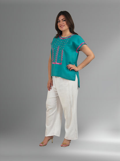 Blusa de lino, bordado estrellitas color jade, borddo rosa y fucsia, vista lateral en modelo.
