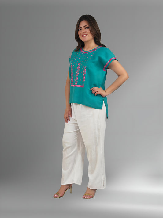 Blusa de lino, bordado estrellitas color jade, borddo rosa y fucsia, vista lateral en modelo.