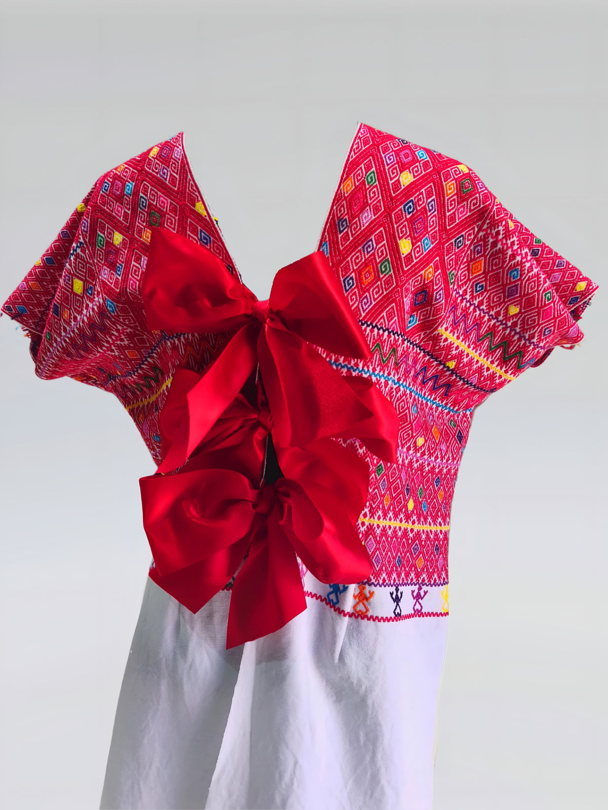 Blusa larga con moños. Brocado Larraínzar color rojo, vista posterior, detalle de los moños.