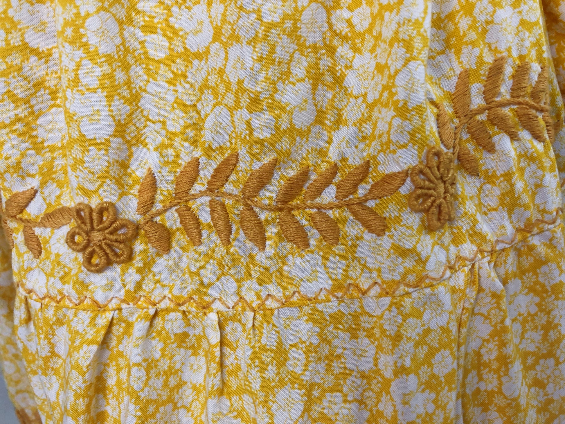 Falda vuelos Aguacatenango color amarillo, floreada, bordado mostaza, detalle del bordado y tela.
