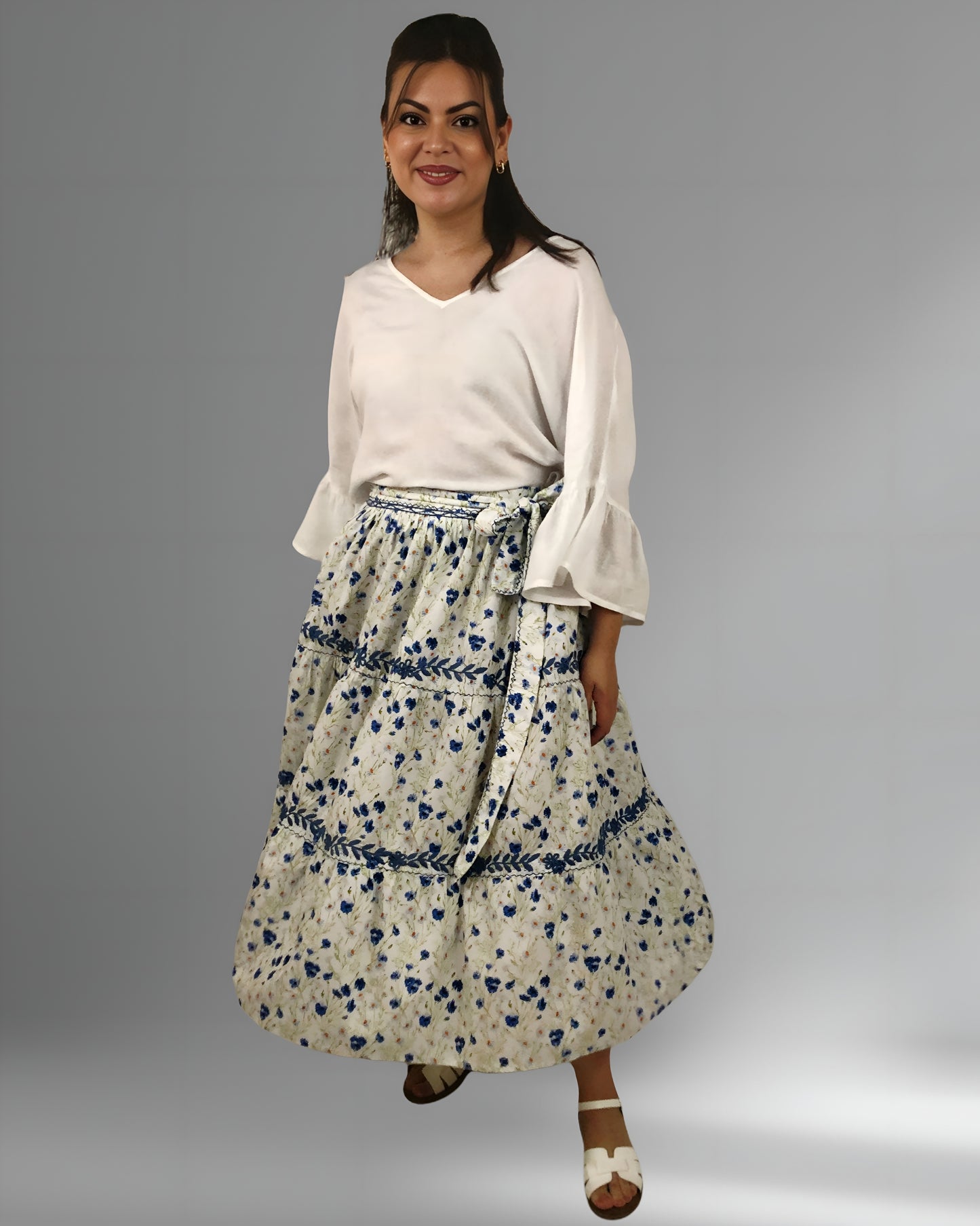 Falda vuelos Aguacatenango color blanco, flores azules con bordado azul, vista en movimiento en modelo.