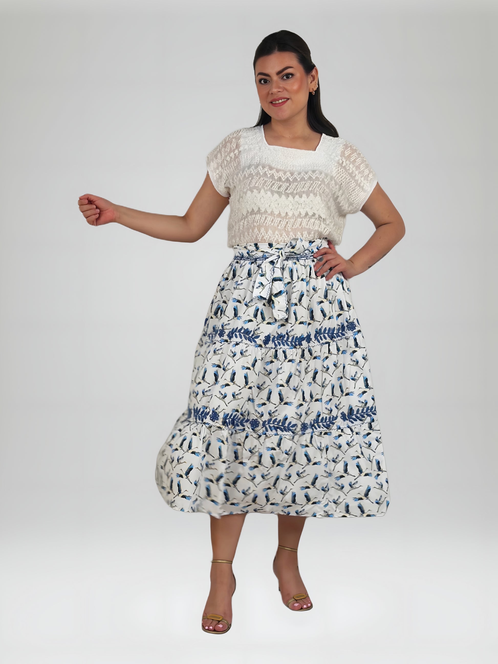 Falda vuelos Aguacatenango color blanco con estampado de garzas, bordado azul, vista en movimiento en modelo