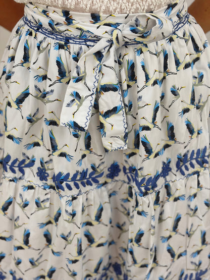 Falda vuelos Aguacatenango color blanco estampado de garzas, bordado azul, detalle del bordado y cinta. 