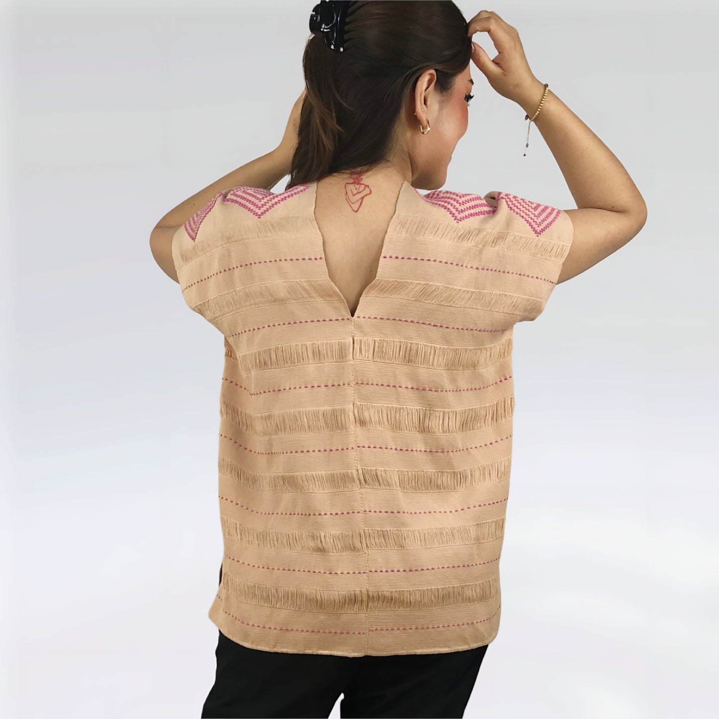 Huipil Rombos Cancuc color beige, detalles en rosa, vista posterior en modelo.