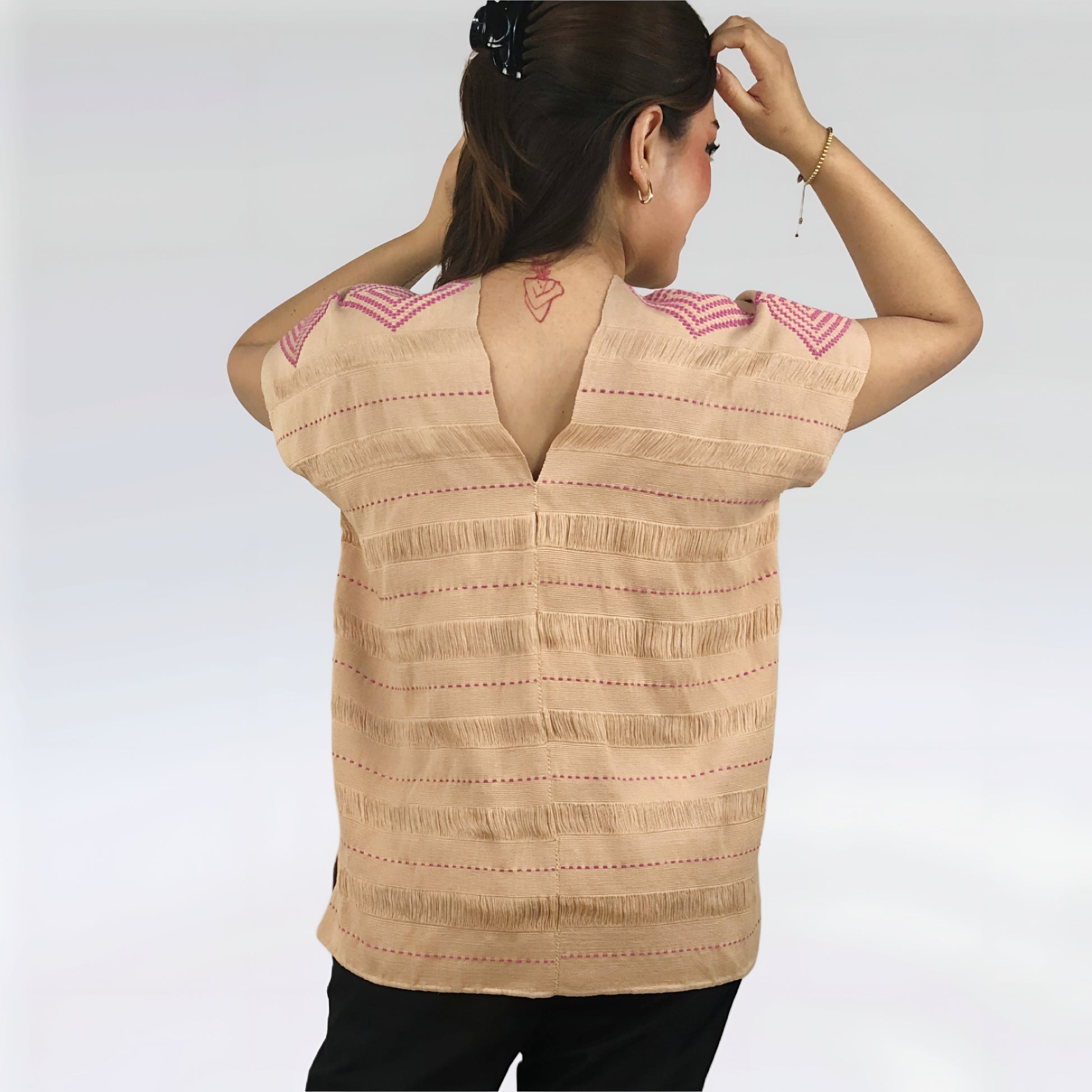 Huipil Rombos Cancuc color beige, detalles en rosa, vista posterior en modelo.