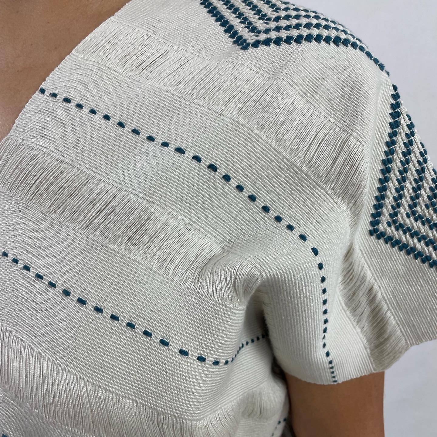 Huipil Rombos Cancuc color blanco, detalle en azul. Vista del tejido y telar.