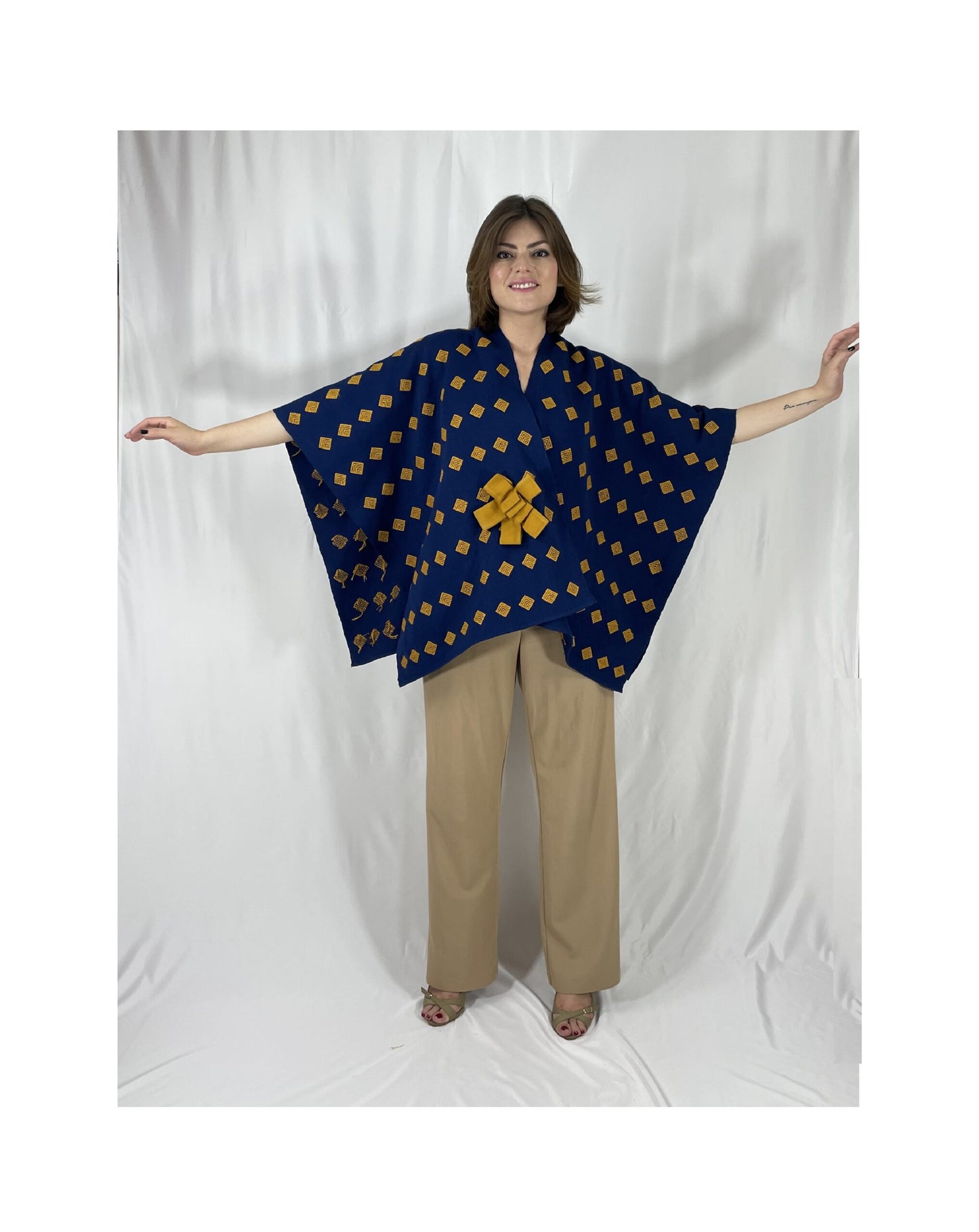 Poncho Algodón Con Flor Larrainzar, en azul marino con mostaza, vista frontal.