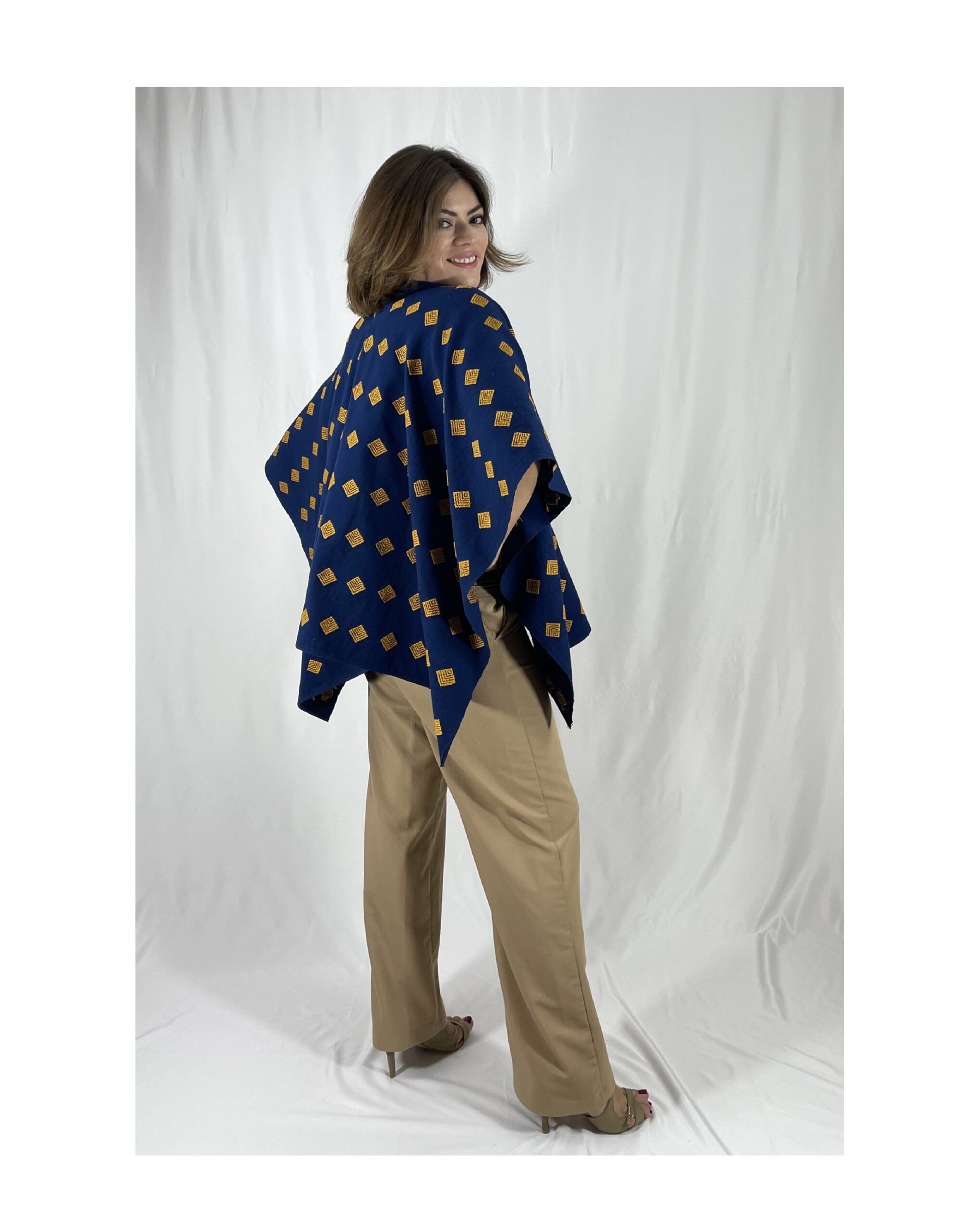 Poncho Algodón Con Flor Larrainzar color azul marino con mostaza, vista lateral en modelo.