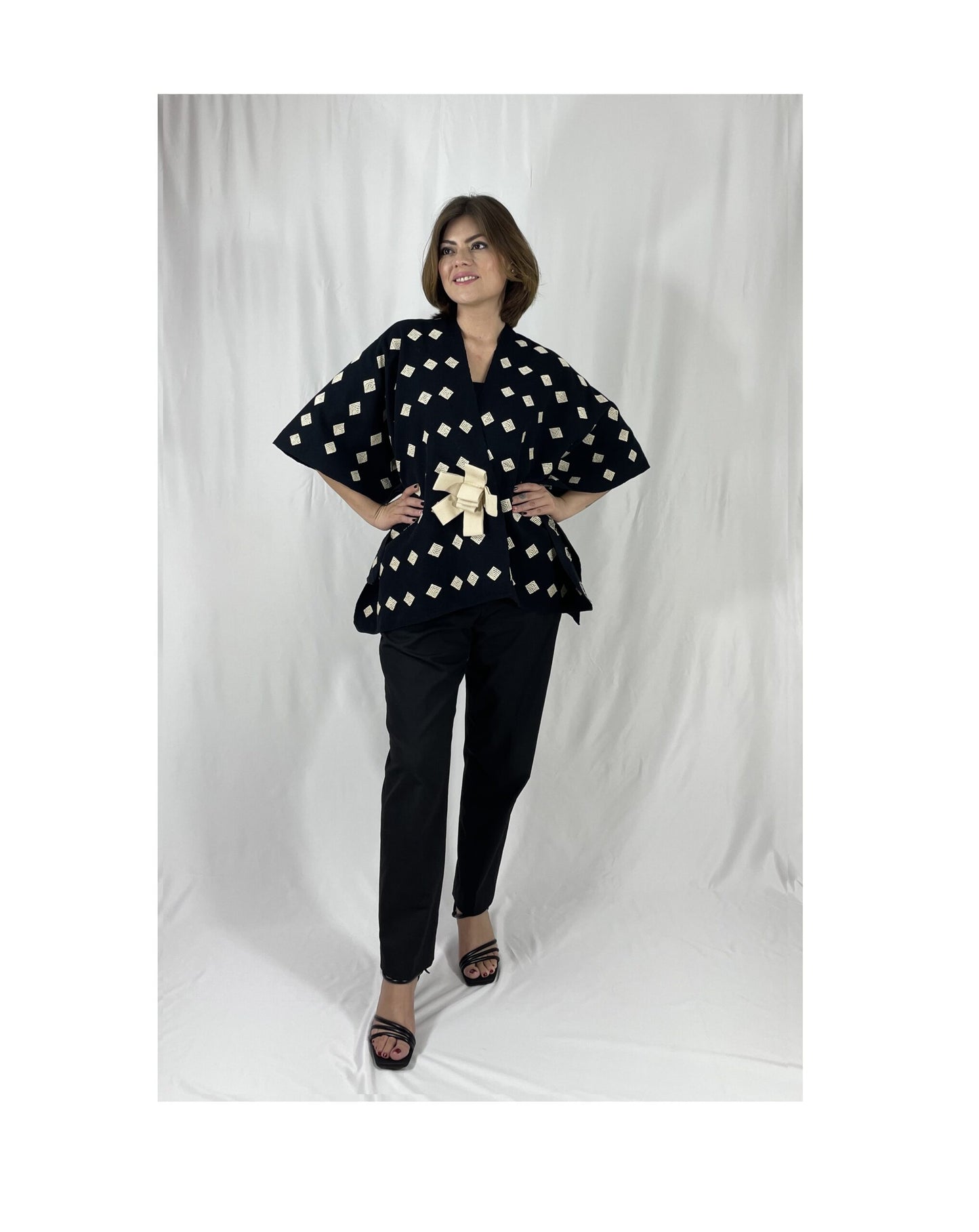 Poncho Algodón Con Flor Larrainzar color negro con beige, vista frontal en modelo.