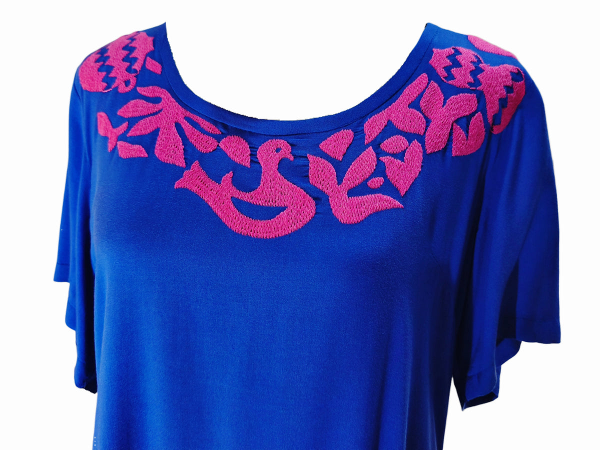 Vestido Palomas color azul, bordado rosado, detalle del bordado en el pecho.