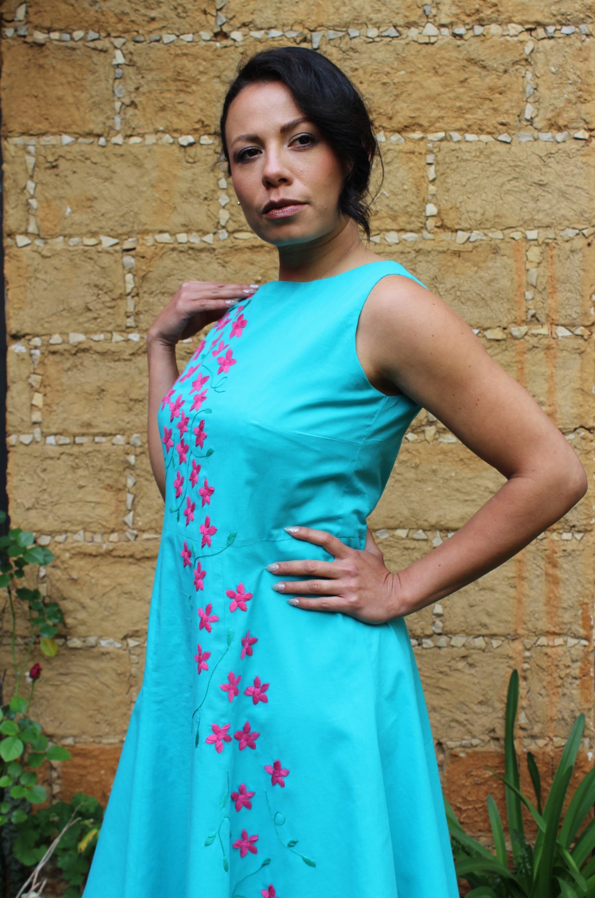 Vestido acampanado, bordado de flores, color turquesa, vista lateral.