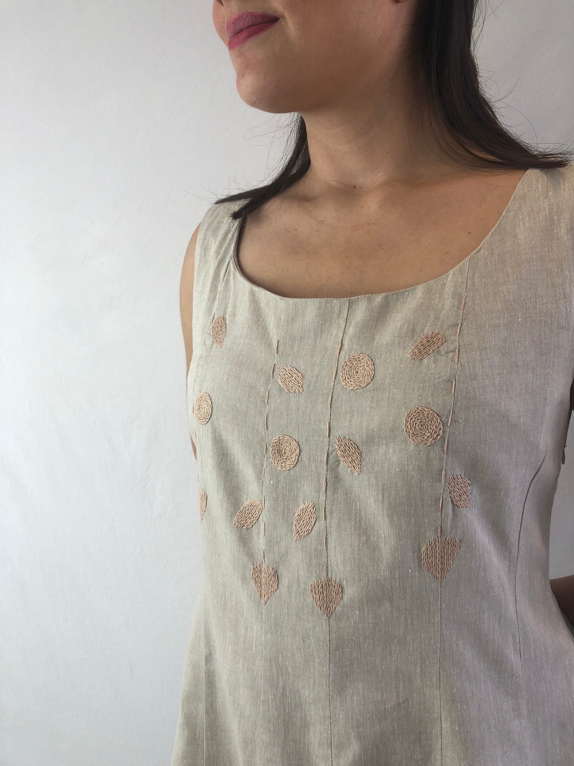 Vestido cuchillas lino-algodón, bordado a mano color beige, acercamiento al bordado en modelo.