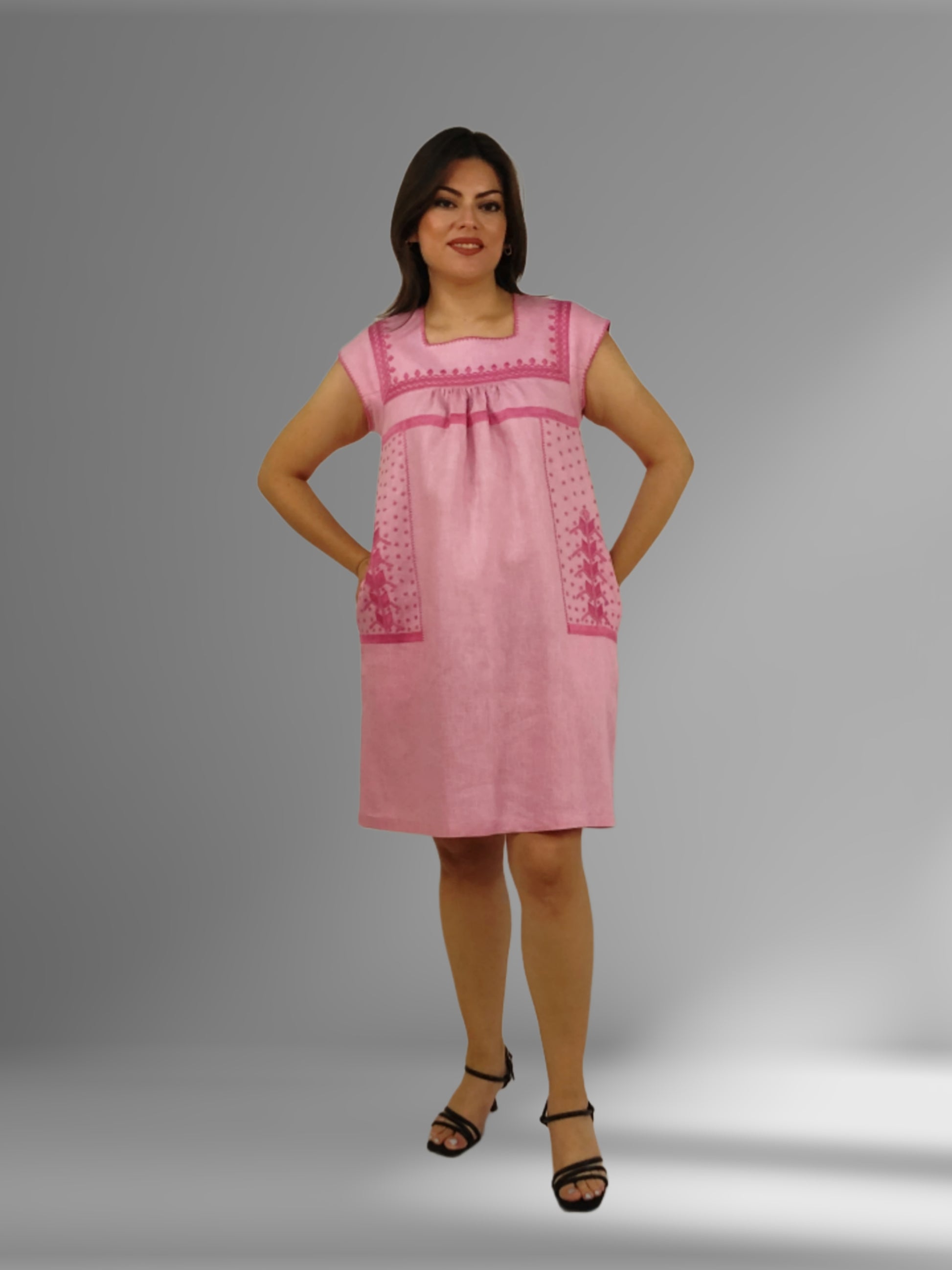 Vestido de Lino con bolsas bordado Milpa en color rosa, vista frontal de la modelo mostrando las bolsas. 