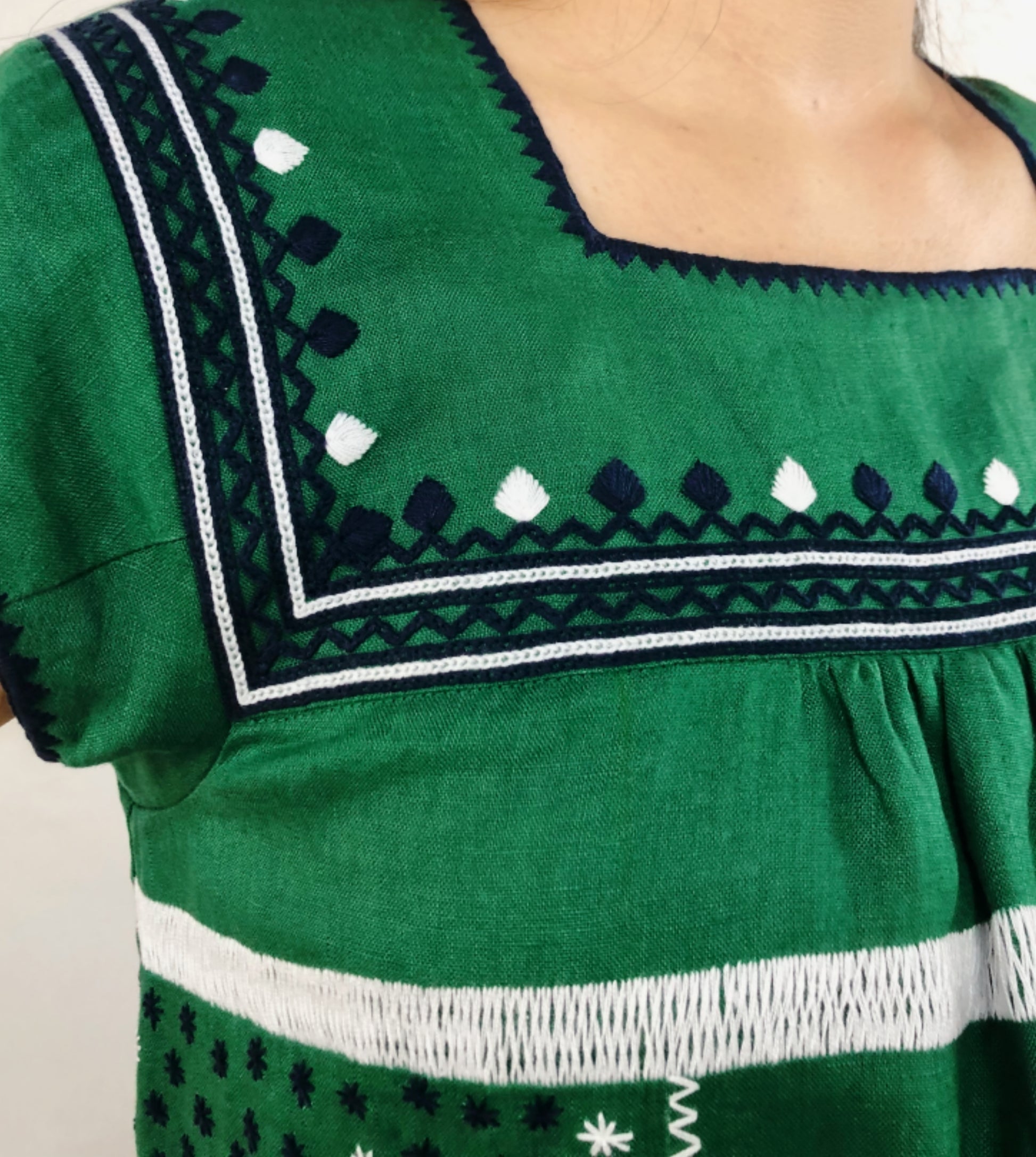 Vestido de Lino con bolsas bordado Milpa color verde, detalle del bordado en azul marino y blanco.