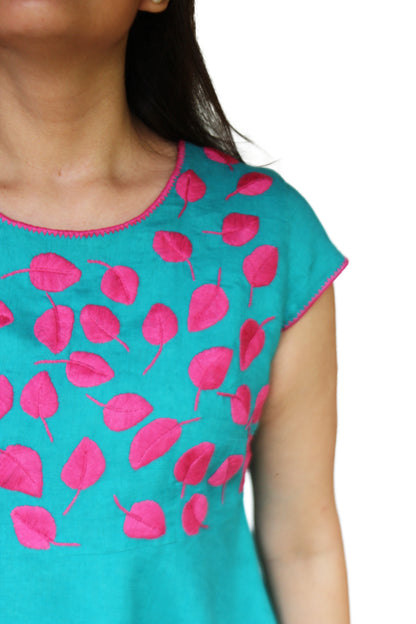 Vestido de lino hojitas color turquesa con bordado fucsia de hojas, detalle del bordado en pecho y cuello.