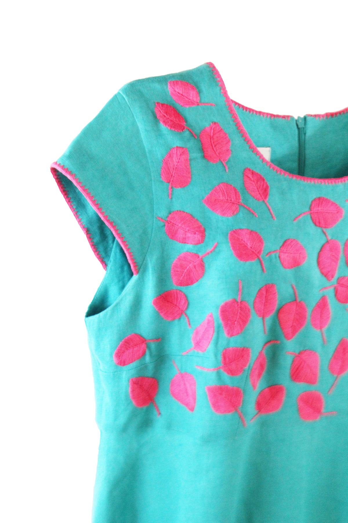 Vestido de lino hojitas color turquesa, bordado fucsia. Detalle de la mang y bordado.